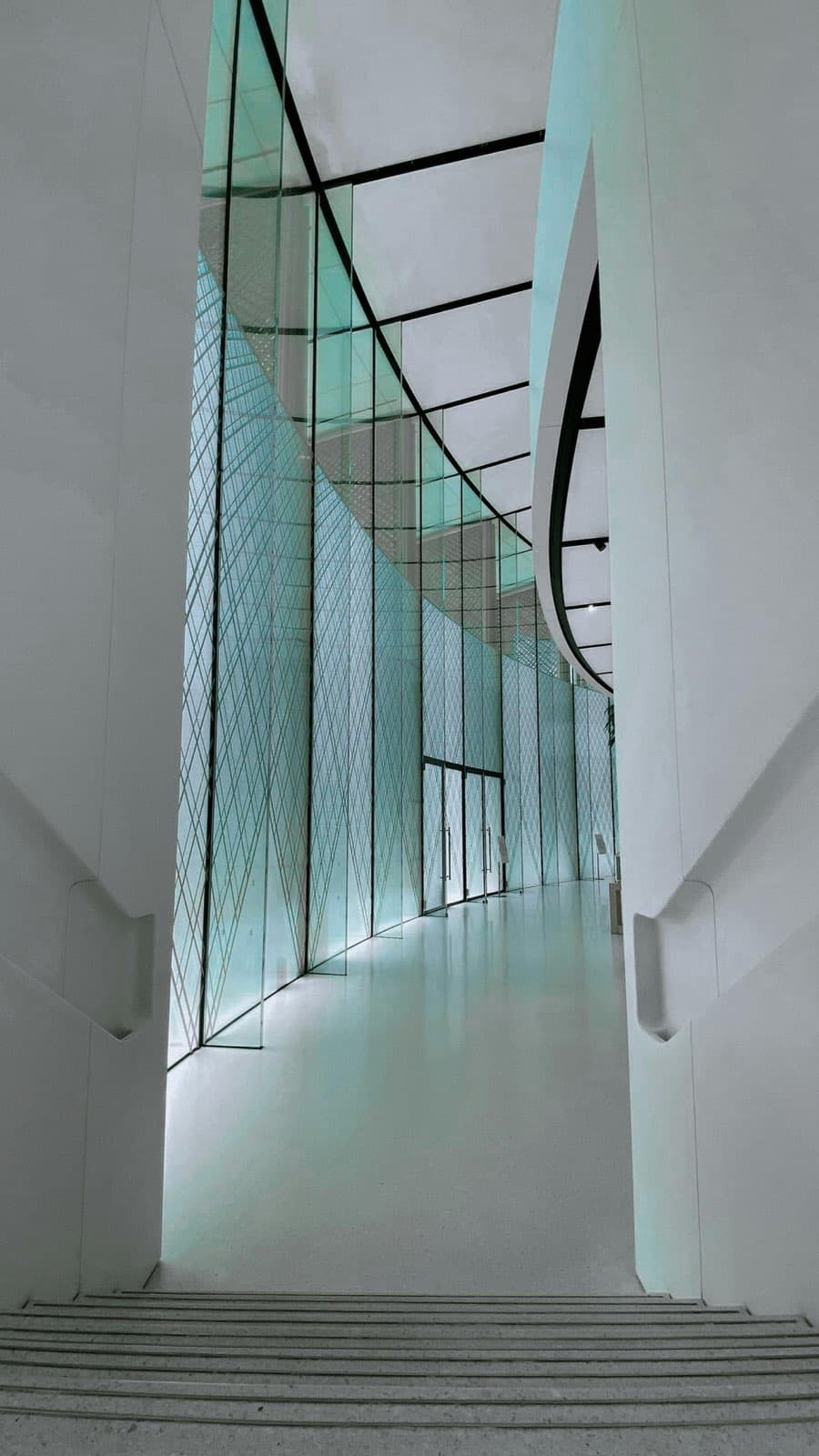 Minimal architectural corridor with soft glass and sculptural lines